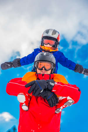 Little boy having fun with his ccaucasian attractive father during skiing in Alps.の写真素材