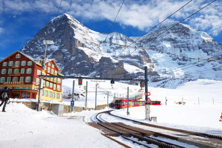 KLEINE SCHEIDEGG, SWITZERLAND - January 2017 - Famous train (Jungfrau railway) goes to Alpine mountain resort with famous Eiger, Monch and Jungfrau mountain, Grindelwald, Berner Oberland, Switzerland.のeditorial素材
