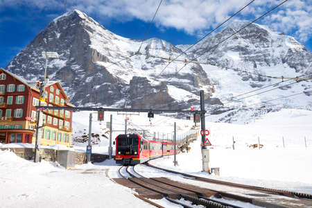 KLEINE SCHEIDEGG, SWITZERLAND - January 2017 - Famous train (Jungfrau railway) goes to Alpine mountain resort with famous Eiger, Monch and Jungfrau mountain, Grindelwald, Berner Oberland, Switzerland.のeditorial素材