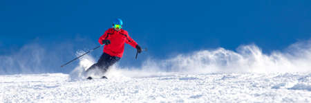 Man skiing on the prepared slope with fresh new powder snow in Tyrolian Alps, Zillertal, Austriaの写真素材