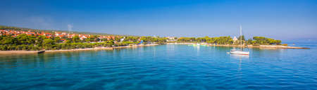 Harbour in Supetar town on Brac island with palm trees and turquoise clear ocean water, Supetar,...