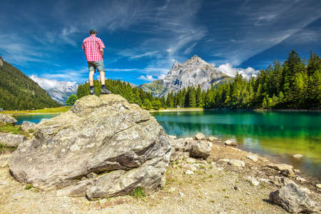 Man enjoying view of Arnisee with Swiss Alps. Arnisee is a reservoir in the Canton of Uri, Switzerland, Europe.の写真素材
