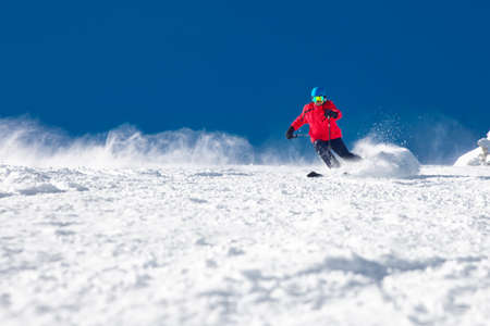 Man skiing on the prepared slope with fresh new powder snow.