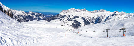 Beautiful winter landscape with Swiss Alps. Skiers skiing in famous Engelgerg - Titlis ski resort, Switzerland, Europe. の写真素材