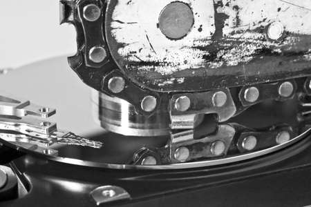 Chain saw over open hard disk drive. symbol for data loss