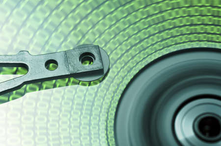 moving hard drive head with green data on driveの写真素材