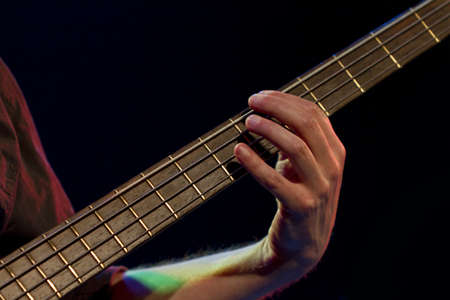 men playing guitar. detail shot in black backgroundの写真素材