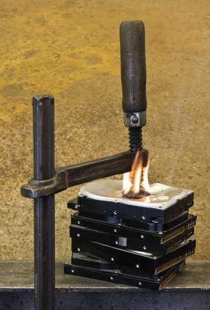 clamp pressing on burning stack of hard drives. Rusty Backgroundの写真素材