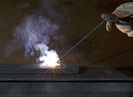 electro-weld a peace of steal in dark background