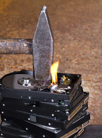 hammer on stack of hard disk in rusty backgroundの写真素材