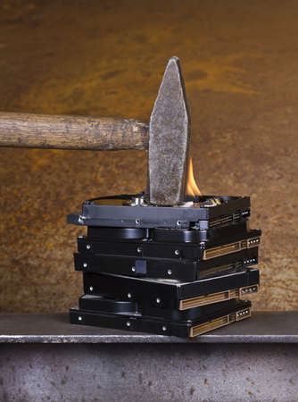 hammer on burning hard disk in rusty backgroundの写真素材