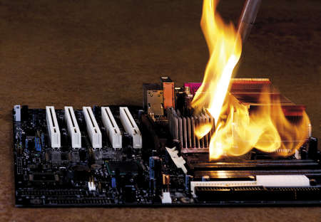 burning computer part on rusty background. modern mainbord overheatedの写真素材