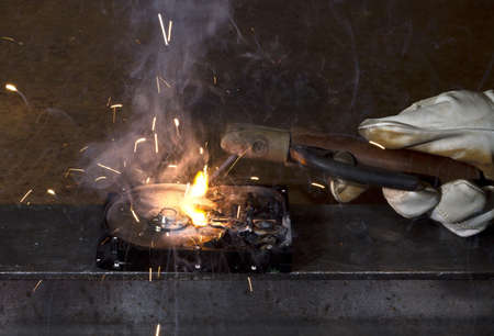 welding on open hard disk drive in dark rusty background. sparks flying awayの写真素材