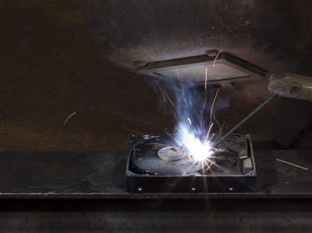 electrical welding on open hard disk drive. Protective shield of steel worker. Copy space