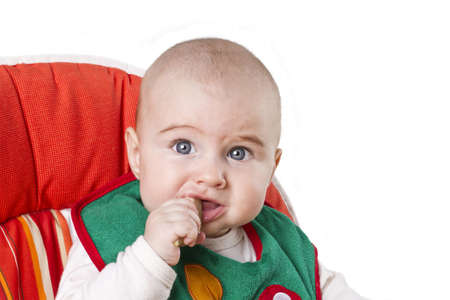 baby eating and looking to camera. isolated on white backgroundの写真素材