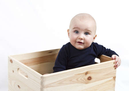 single toddler in wooden box looking to the cameraの写真素材