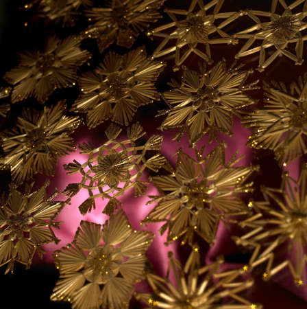 full frame studio photography showing a christmas background with red fabrics and gold toned straw starsの写真素材