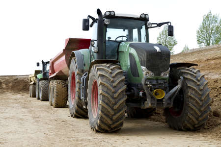 green tractor with hanger on construction site