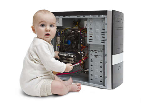 young child with screwdriver in hand working on open computer in white background.の写真素材