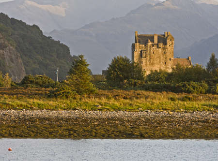 ancient castle in scotland with forest and mountains in backgroundのeditorial素材