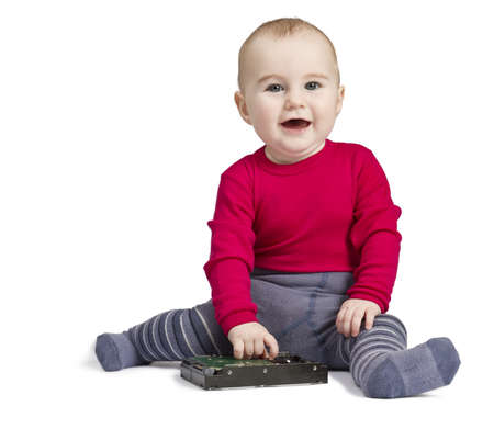 young child in white background with hard drive. red shirt and blue trousersの写真素材