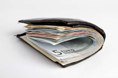 many banknotes in black wallet on light background