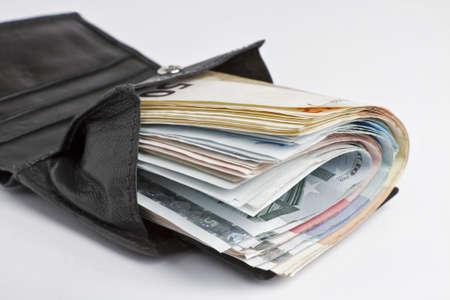 many banknotes in black wallet on light backgroundの写真素材