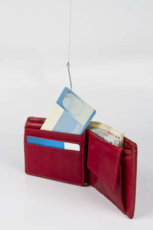 stealing cash card out of red wallet -  neutral grey backgroundの写真素材