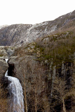 waterfall in mountains of norway with treesの写真素材
