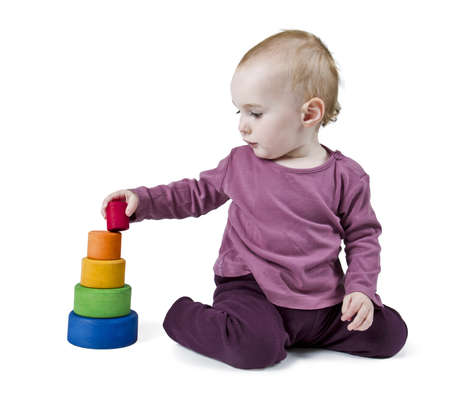 young child playing with colorful toy blocks in white backgroundの写真素材