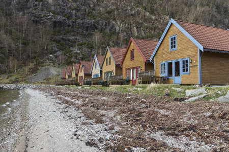 many small colored holiday homes at coastline in norwayの写真素材