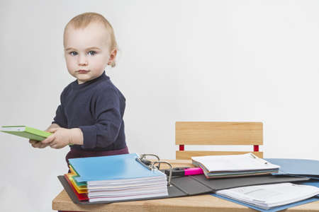 young child working at writing desk in light backgroundの写真素材