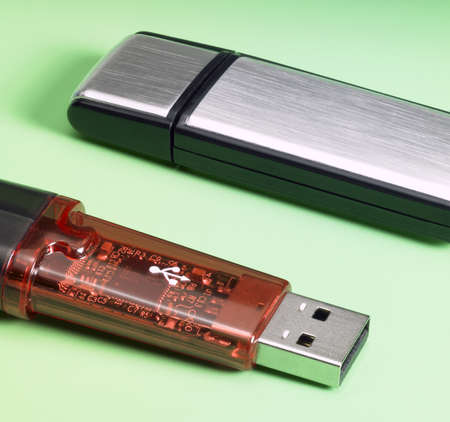 studio photography of 2 USB sticks in green backの写真素材