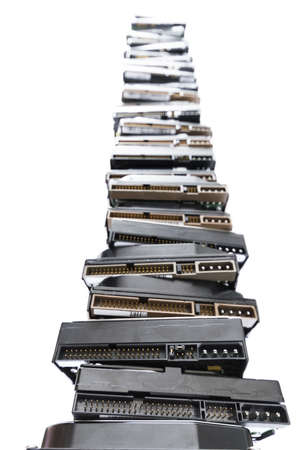 high stack of used hard drives in light background
