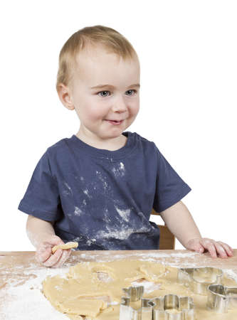 young child making cookies on small wooden deskの写真素材