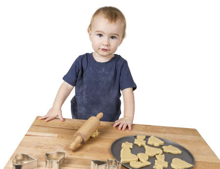 young child making cookies on small wooden deskの写真素材