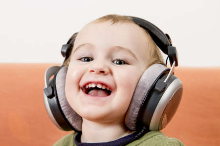 young child on couch with big earphoneの写真素材