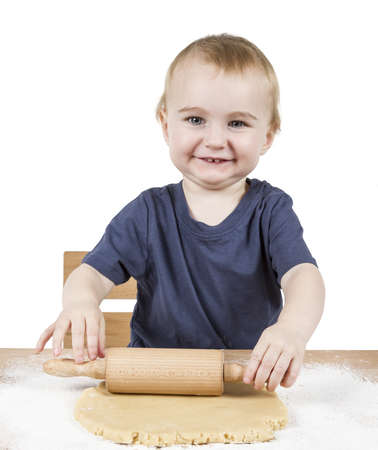 young child making cookies on small wooden deskの写真素材