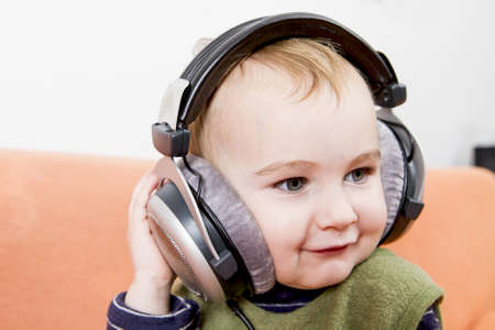 young child on couch with big earphoneの写真素材