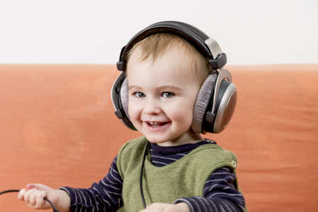 young child on couch with big earphoneの写真素材