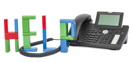 the word help made with toy bricks and a business phone in background の写真素材