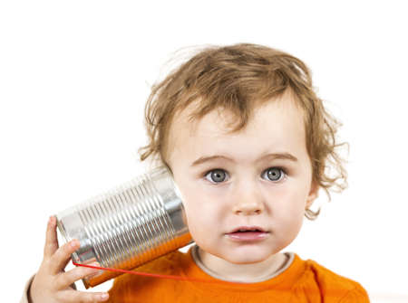 young caucasian child with tin can phone looking to cameraの写真素材