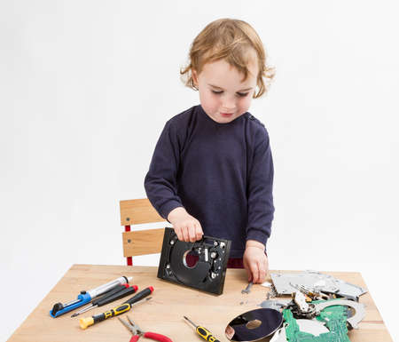preschooler with computer parts on wooden desk  studio shot in light grey backgroundの写真素材