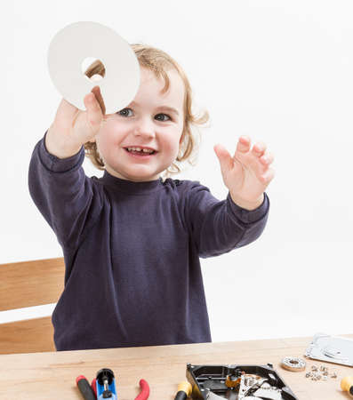 child repairing computer part  studio shot in light grey background