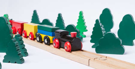 black wooden toy train in rural landscape made with simple toy treesの写真素材