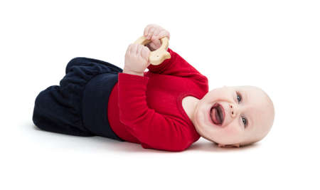 laughing baby in red shirt on floor. isolated on white backgroundの写真素材
