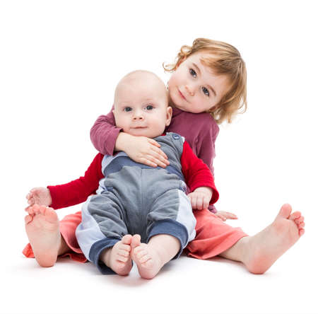 boy and girl sitting on floor. isolated on white backgroundの写真素材