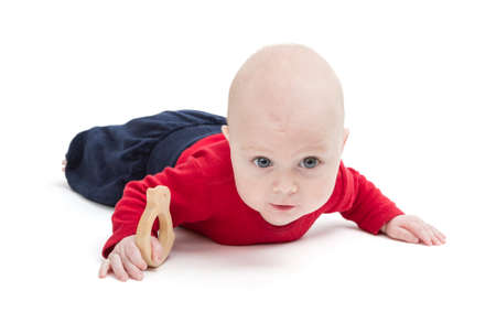 toddler crawling on floor with toy in hand  studio shotの写真素材