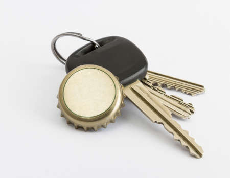 car key and bottle cap in close up with neutral grey backgroundの写真素材