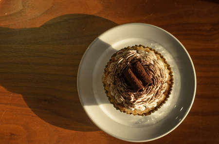 Cupcake white cream and chocolate roll with  chocolate powder in coffee shop